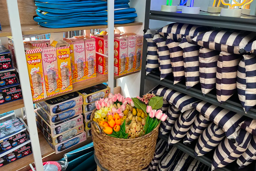 商店內照，展示了清晰排列的條狀墊子和多種桌遊套件，營造出豐富多彩的野餐或露營選擇。