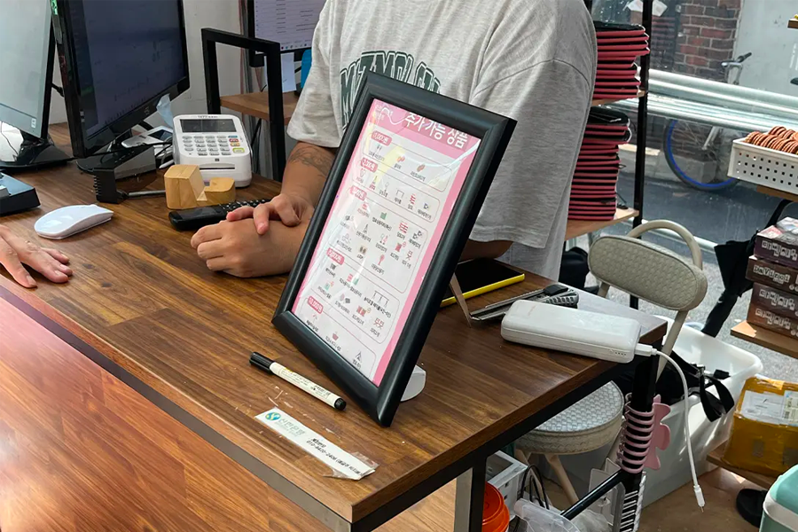 租借露營用品的商店櫃檯，顧客正在租借或詢問野餐相關用具的服務。