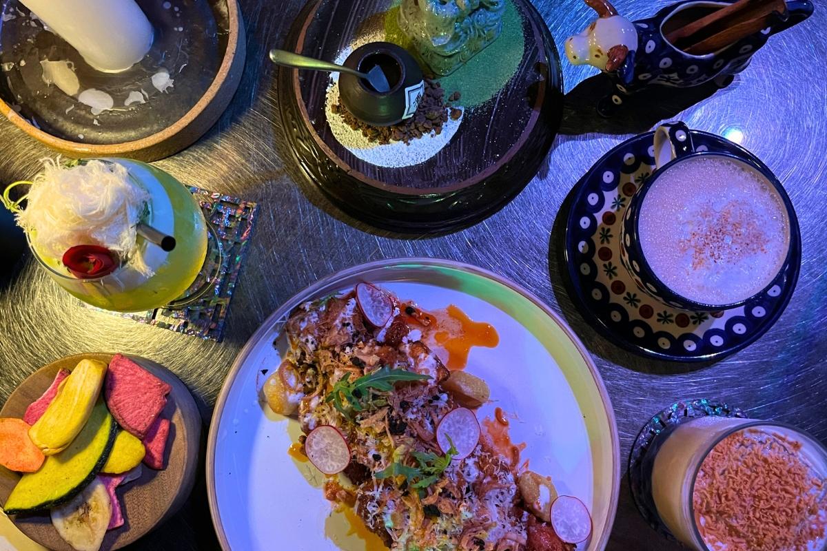 Анжурное блюдо и коктейли на столе в коктейль-баре Zoo Sindang с разнообразными закусками.