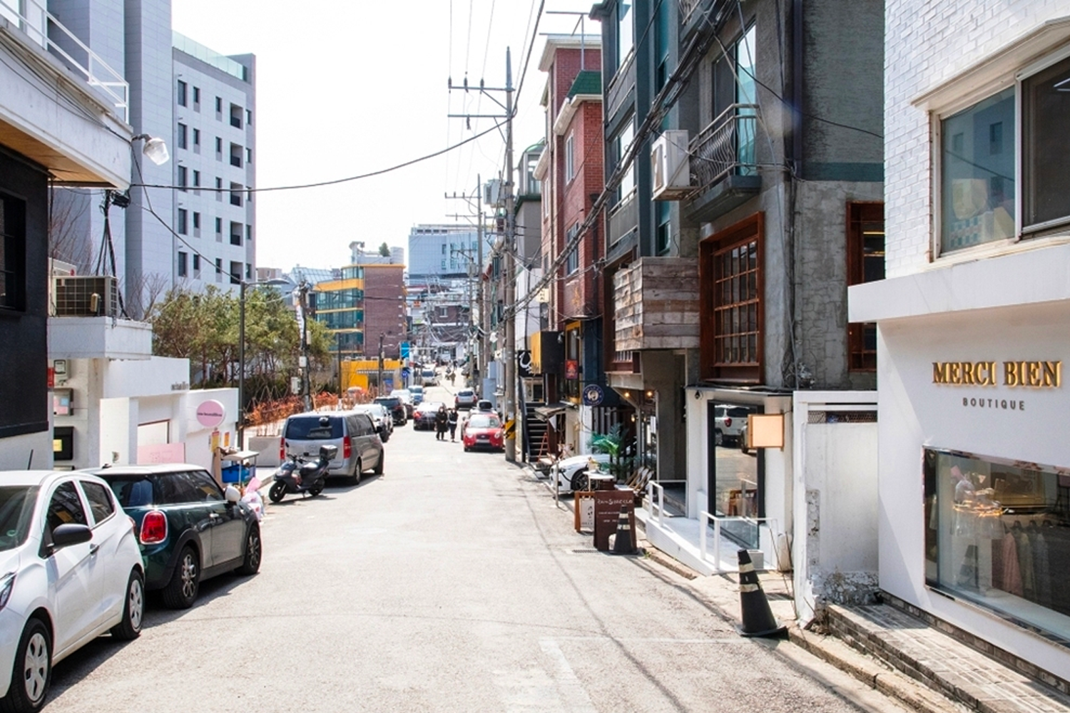 漢南洞的簡約風格展示，寬敞的街道背景和模特的時尚搭配形成對比，體現現代與國際風格的交融。