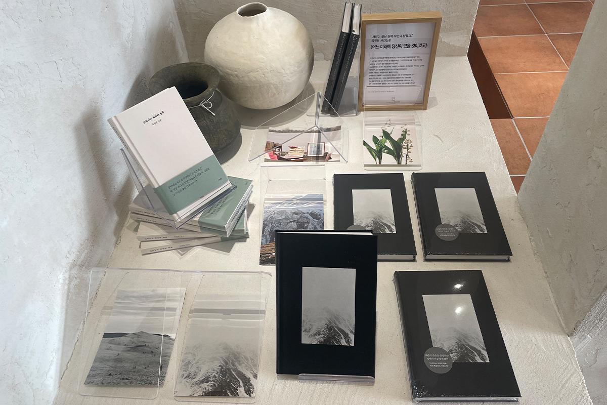 Зона отдыха в книжном кафе Sea Sea with Book с стеклянными окнами и видом на океан.