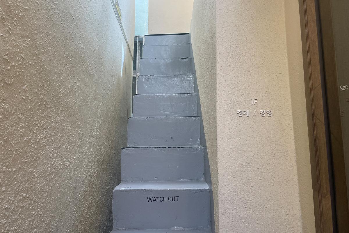 Высокая лестница внутри книжного кафе Sea Sea with Book с предупреждением "Watch Out".