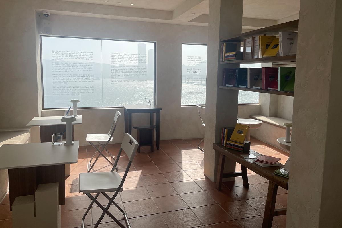 Вид на книжный кафе Sea Sea with Book с выставленными книгами и элементами дизайна.