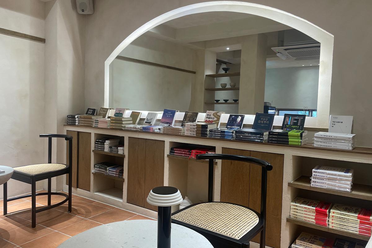 Книжный стенд с разнообразными книгами и минималистскими мебельными элементами в интерьере.