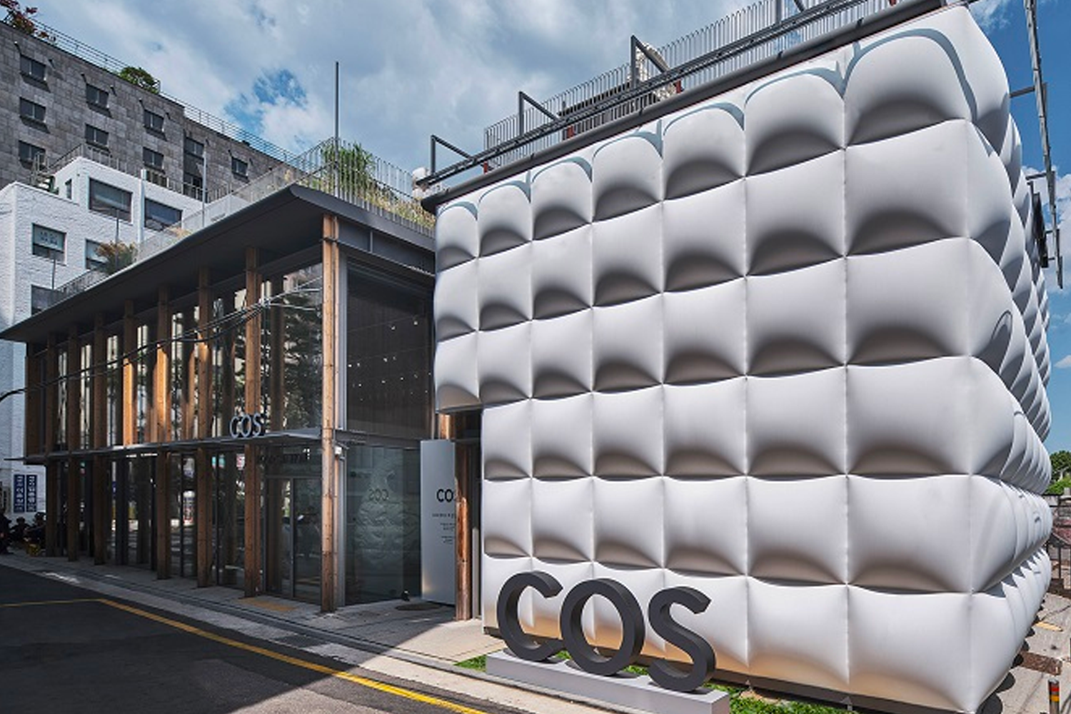 COS在首爾的快闪店外观，展示了标志性的云朵包设计，外墙被设计成类似云朵的装置。