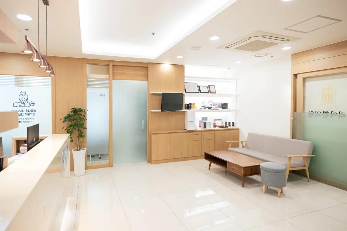 待合エリアの様子を映した写真。木製の傢俱とクリアなガラスドアが見え、モダンで落ち着いた雰囲気が漂う。