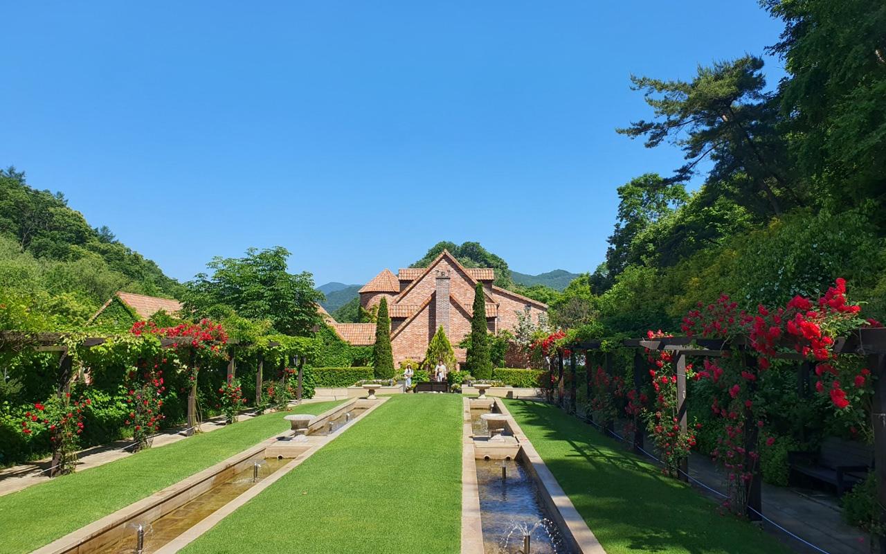 Jade Garden's European-style architecture with vibrant flower beds and manicured lawns, perfect for a tranquil stroll.
