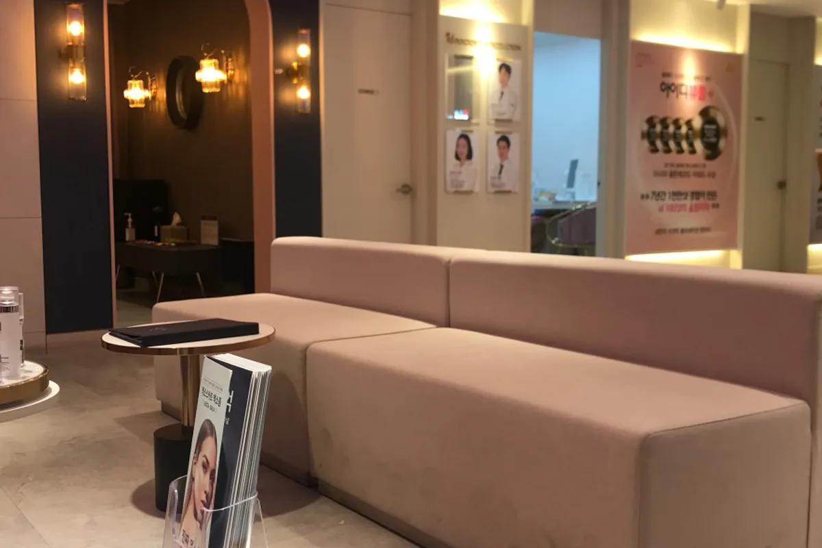 韓国id美容クリニックの待合室、暖かみのある照明と快適なソファが見える。リラックスした雰囲気のインテリアデザイン。