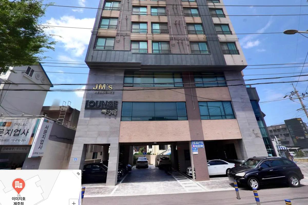 제주도에 위치한 image HO 건물의 외관 이미지, 현대적인 디자인의 건물이 파란 하늘 아래 서 있는 모습