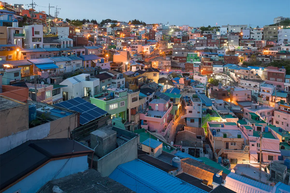 Ночной вид на культурную деревню Гамчхон с яркими огнями и красочными домами.