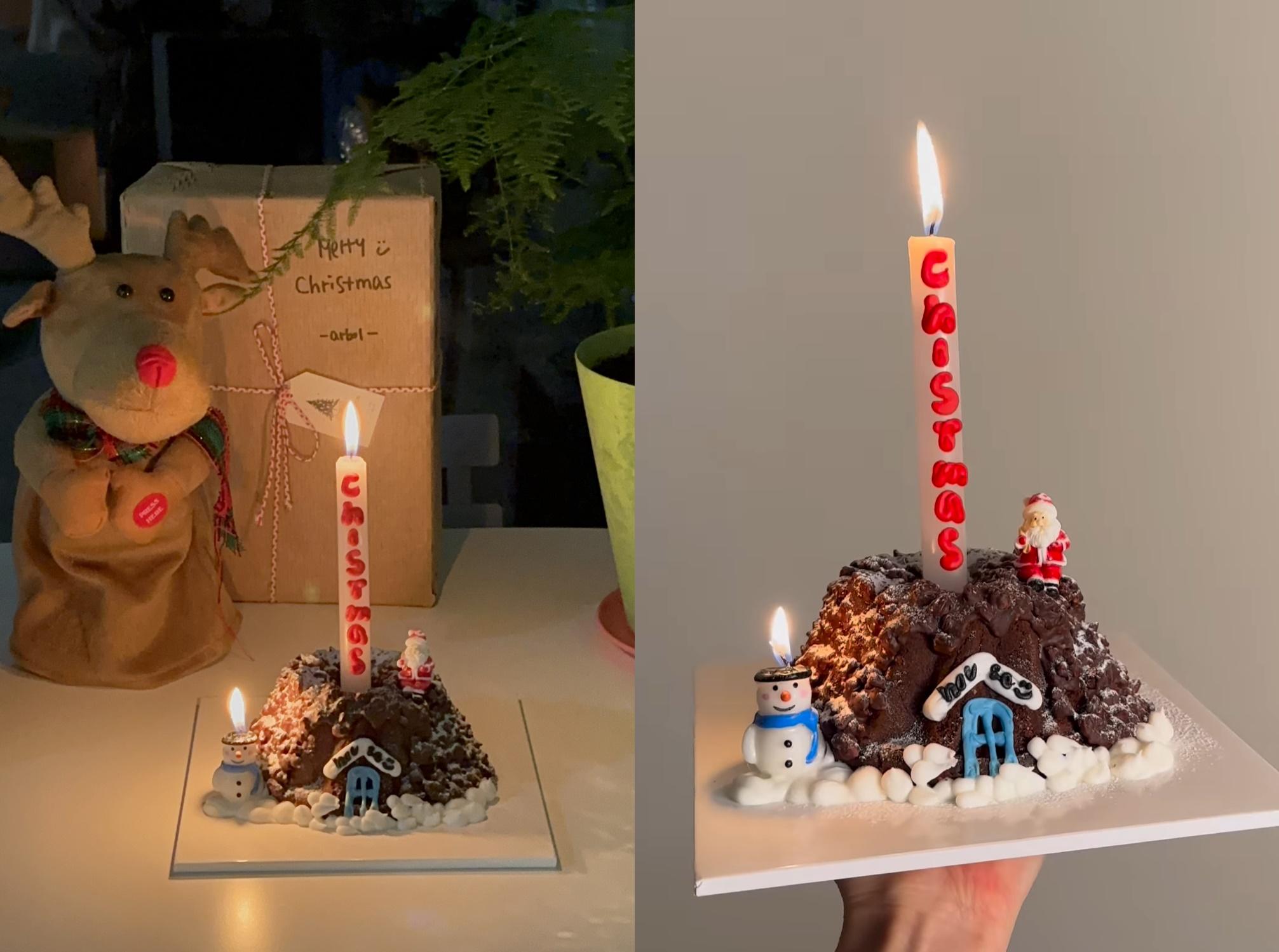 Maison de Noël en gâteau avec cheminée et sapin, décorée pour une ambiance festive par Ours Coffee à Jeju.