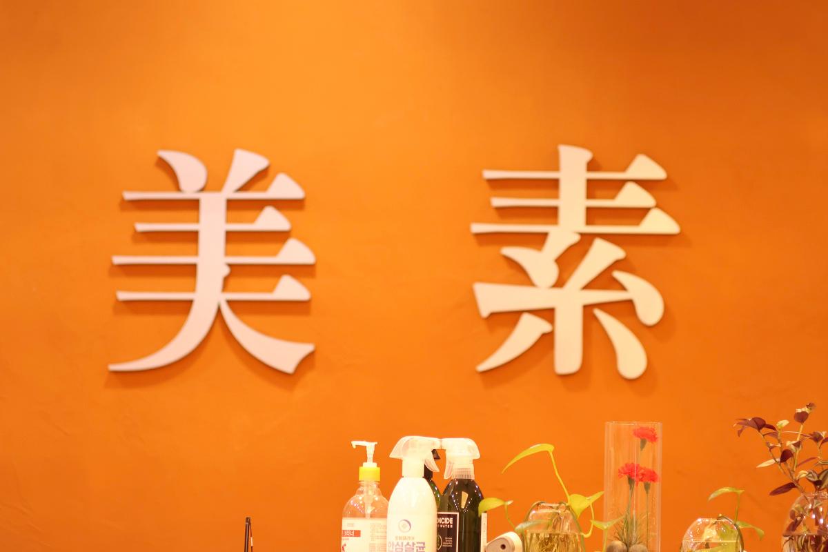 韓國美素三溫暖接待臺的背景牆上，顯示著“美素”的字樣。