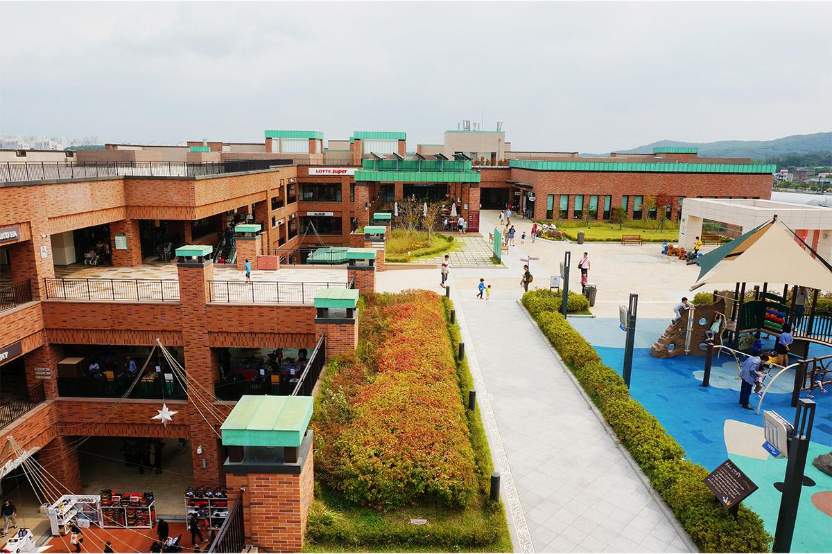 롯데 파주 아울렛의 외부와 내부 매장 모습, 쇼핑객들이 걷고 있는 모습