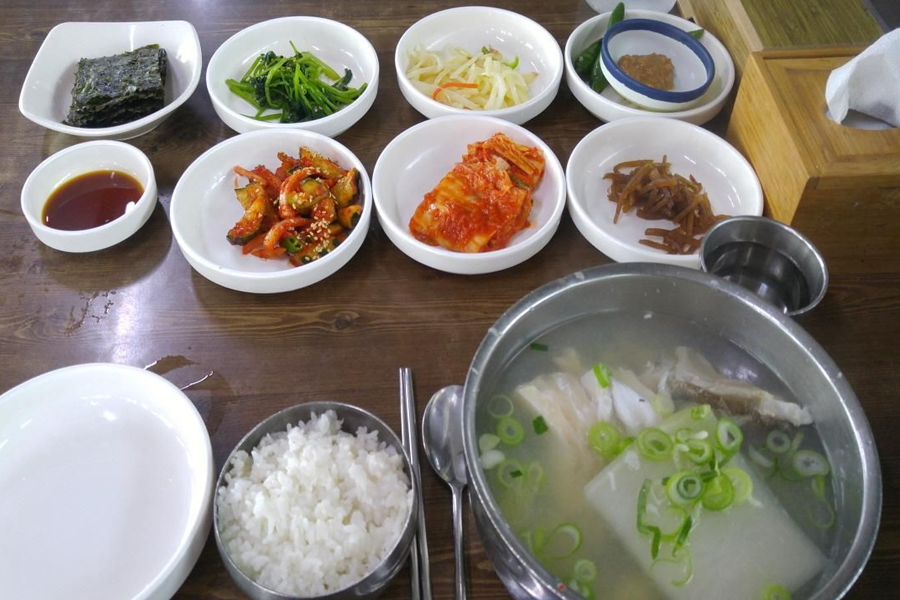 Một mâm súp cá tuyết cùng các món phụ tại nhà hàng Haeundae Giwajip Daegu Soup, nổi bật với những nguyên liệu tươi ngon và trình bày tinh tế.