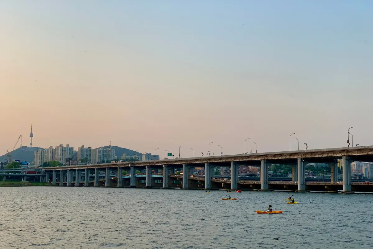 漢江大橋上的車輛行駛，背景是韓國的城市天際線。