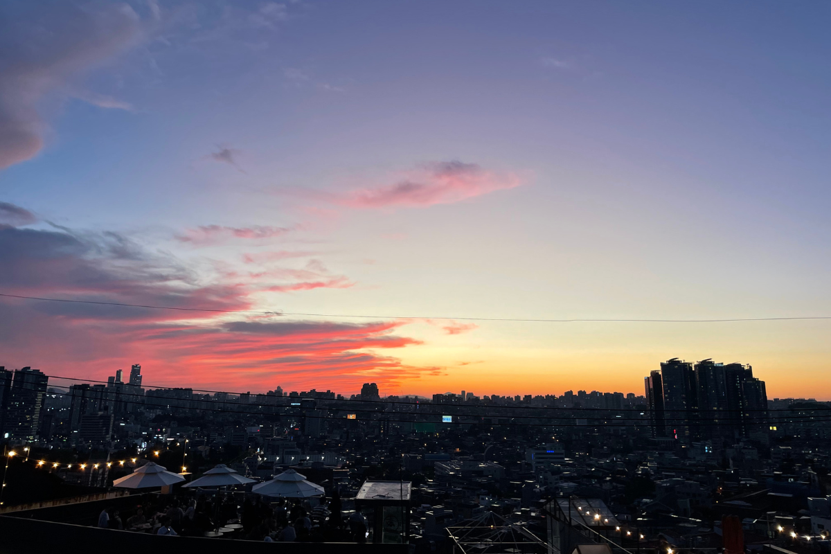 Panoramablick auf die Stadt Seoul bei Sonnenuntergang mit markanten orangefarbenen Wolken am Himmel.