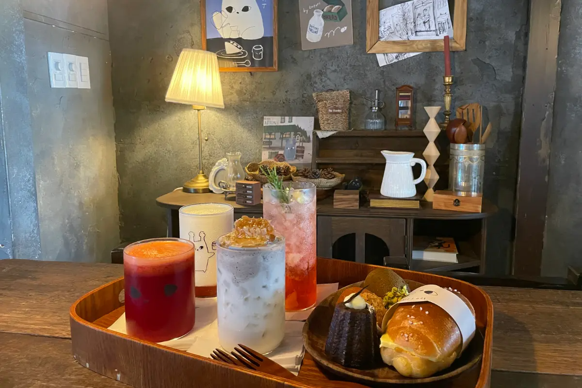 Innenansicht des Dotori Cafés mit einer Auswahl an farbenfrohen Getränken und Gebäck auf einem Tisch.