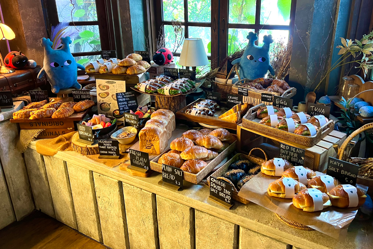 Vielfältiges Bäckersortiment im Dotori Café, präsentiert in rustikalen Holzregalen.