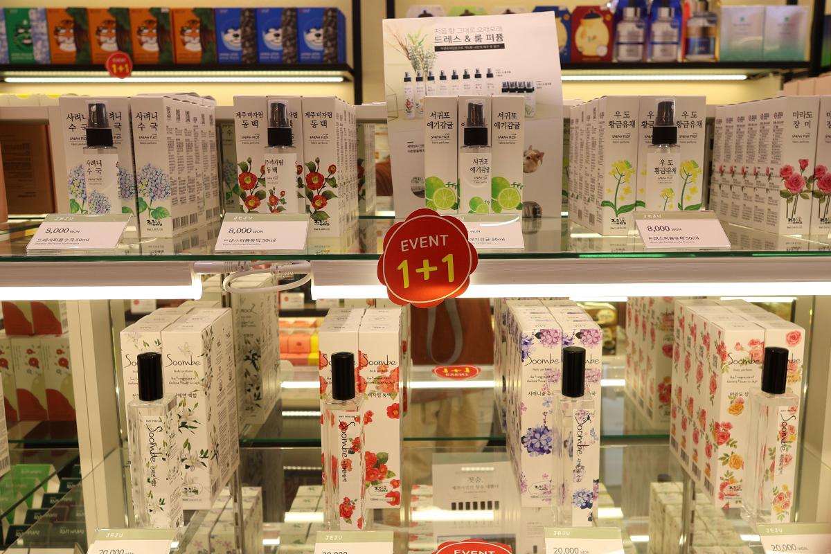 Display of Jeju Island themed cosmetics, featuring vibrant packaging and special promotions at SD Store.