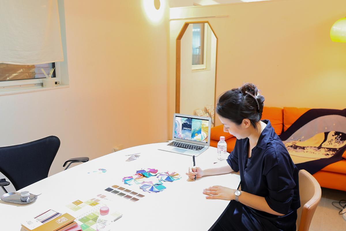 Освещенная комната внутри студии для персонального анализа цветотипа с ноутбуком и цветными палитрами на столе.