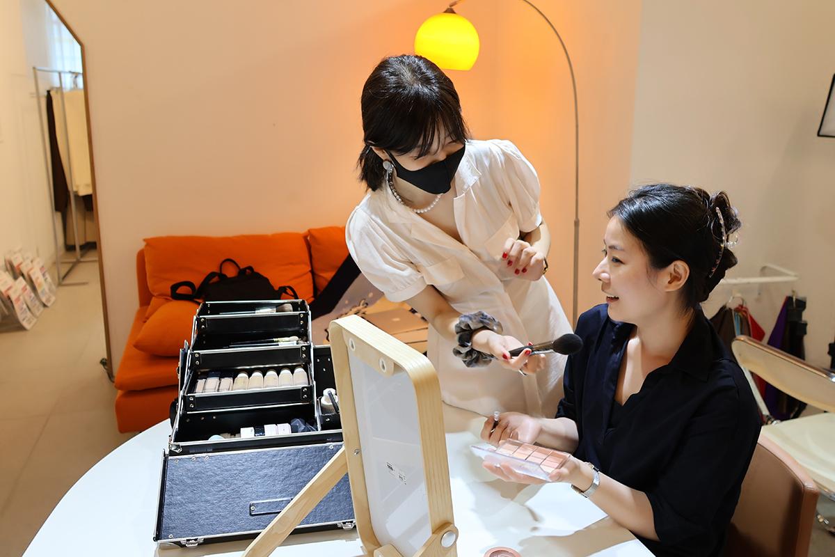 彩妆教学中,讲师根据个人色彩检测结果进行化妆方式指导。