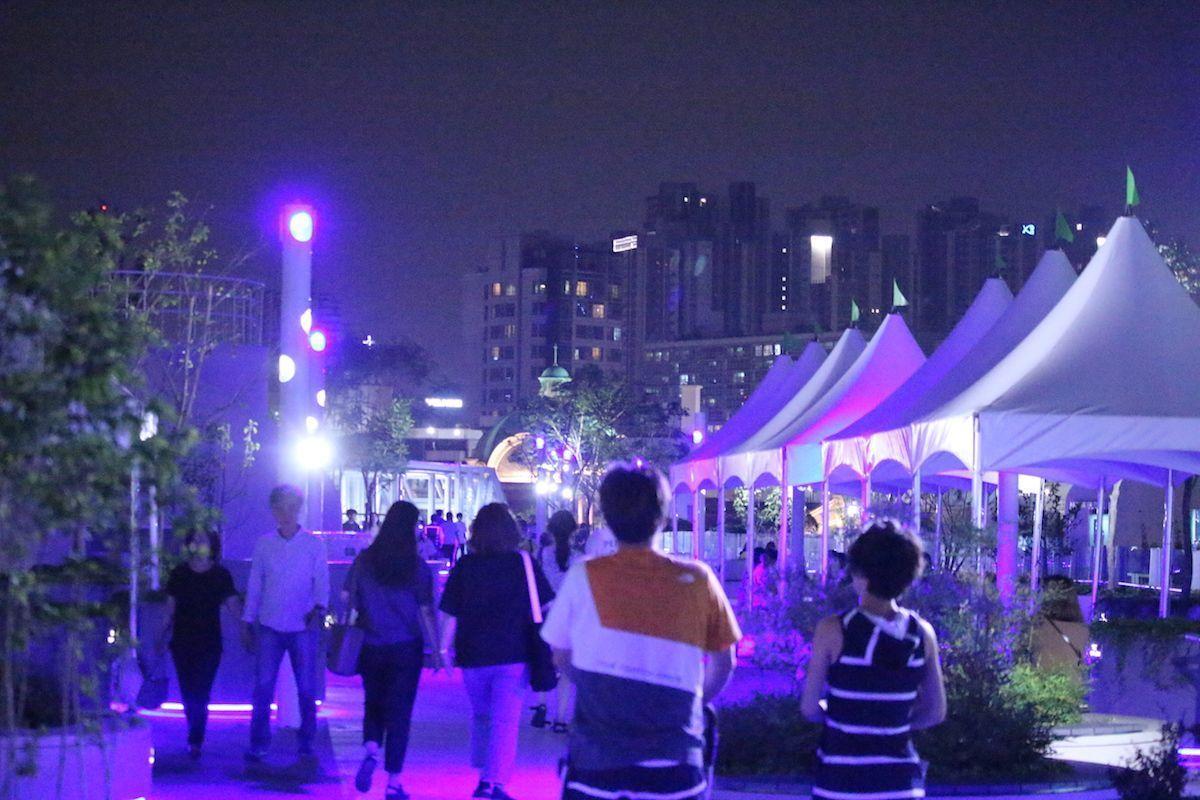 View of Seoullo 7017 illuminated at night, highlighting the pathway's vibrant purple lighting and festive atmosphere.