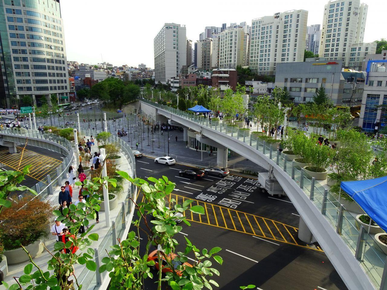 Aerial view of Seoullo 7017, a popular pedestrian walkway and urban park in Seoul, featuring lush greenery and modern architecture against the cityscape.
