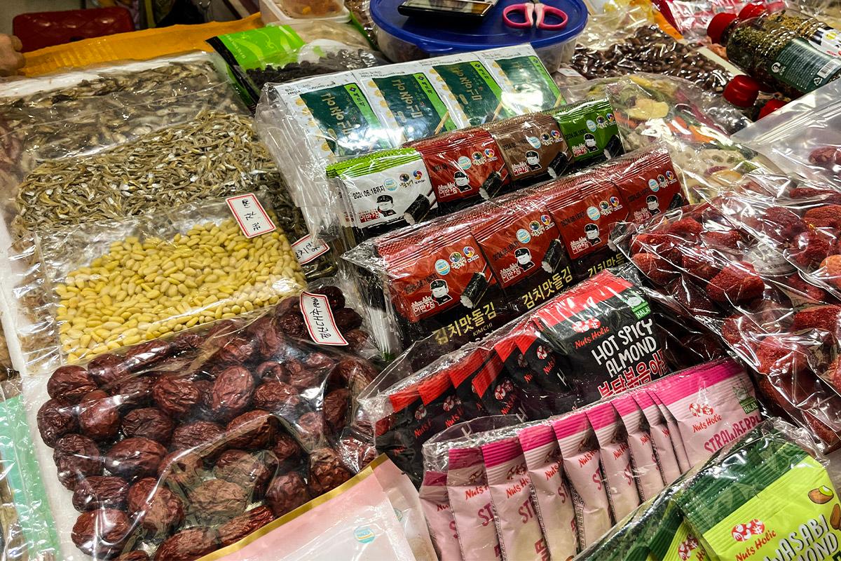 Raccolta di datteri essiccati, pinoli e alghe marine al Mercato di Gwangjang, Corea, ideale per gli amanti dei cibi secchi e nutrienti.