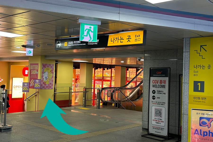 弘大入口站1號出口，指標指向Butter店的方向