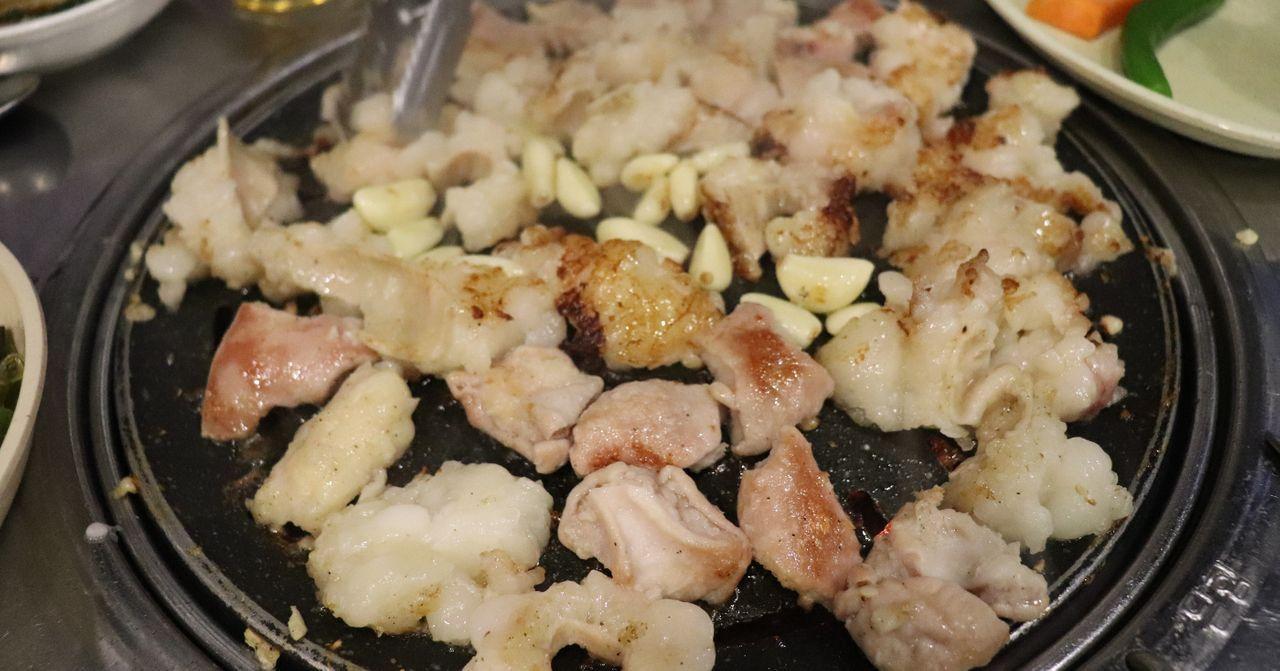 Delicious grilled Korean hanwoo beef and intestines presented on a sizzling hot plate.