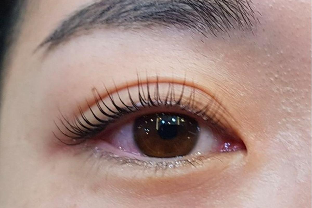 Natural-looking eyelash perm on a client's eye, enhancing the lash curl.