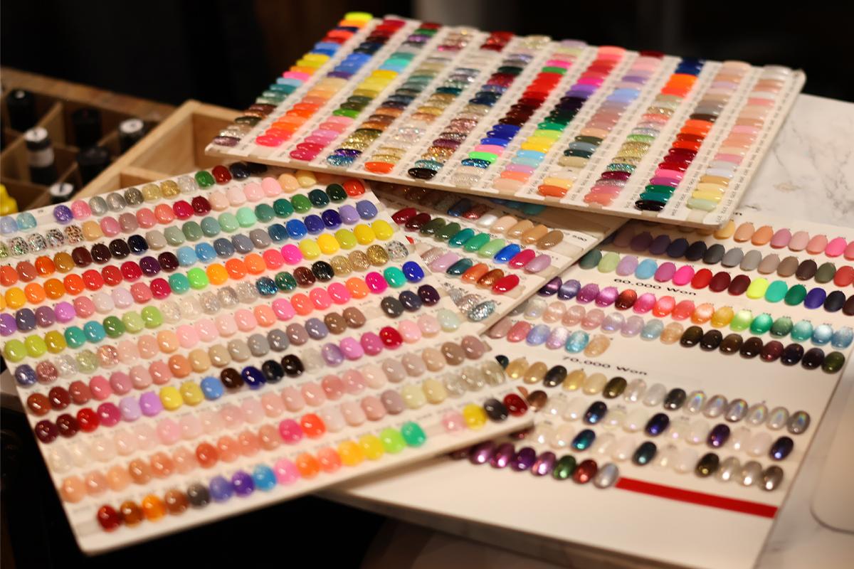Samples of nail art with a colorful selection of polish set out at the salon.