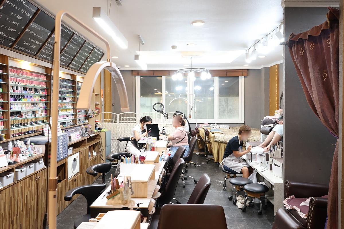 Inside view of a busy nail salon with customers receiving nail care services.