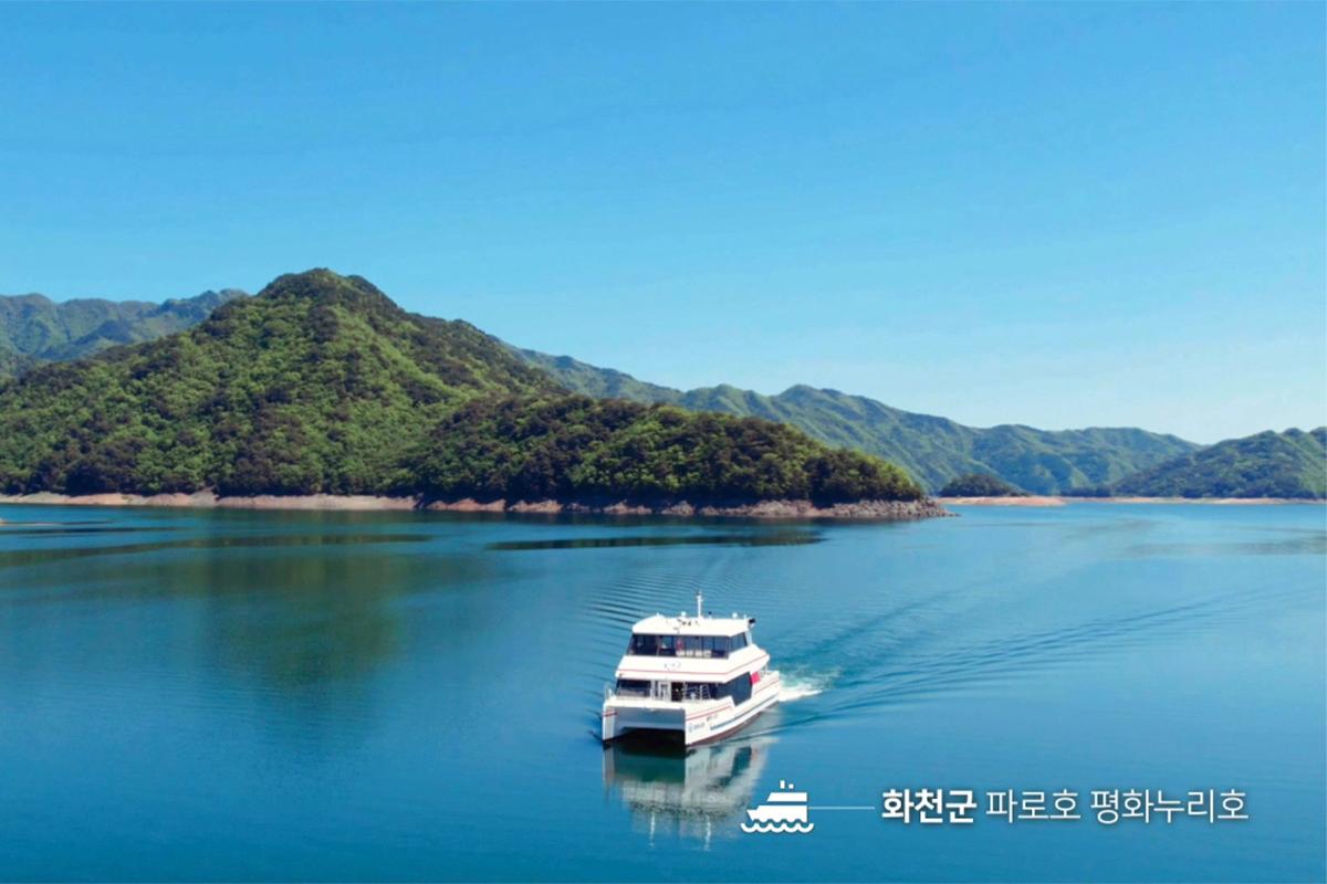 Энх тайван Нури хөлгийн зөөвөр галт тэргүү ба Паро хотын дээд хэсгийн зураг Хойт Солонгосын байдлыг дүрслэгдэнэ. Гүн цэнхэр усан дээр забууд арын талбайн горхи уулнуудын бөгтгөөр харагдаж байна.