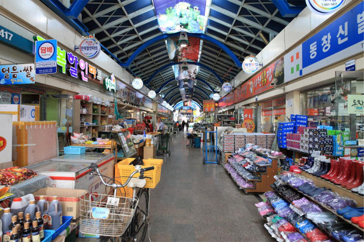 Hwacheon Уламжлалт Захын доторх зураг. Хэсэг хэсэгт байршиж буй жижиг дэлгүүрүүд шугаман байрлалтай. Дэлгүүрийн эгнээний дотор баатарын тэмдэгтүүд.