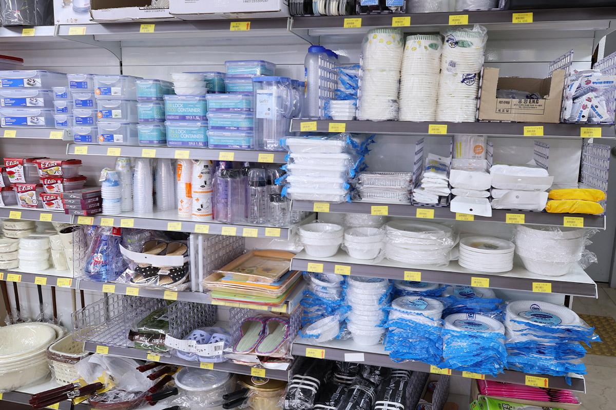 Shelves containing essential household items and containers at Hongdae Mart 24 Hours.