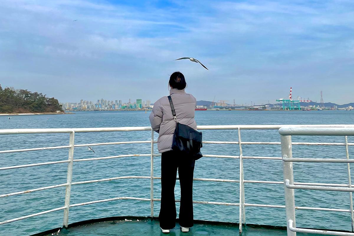 Пассажир на лодке на острове Вольмидо наблюдает за окружающим видом, наслаждаясь спокойствием моря.