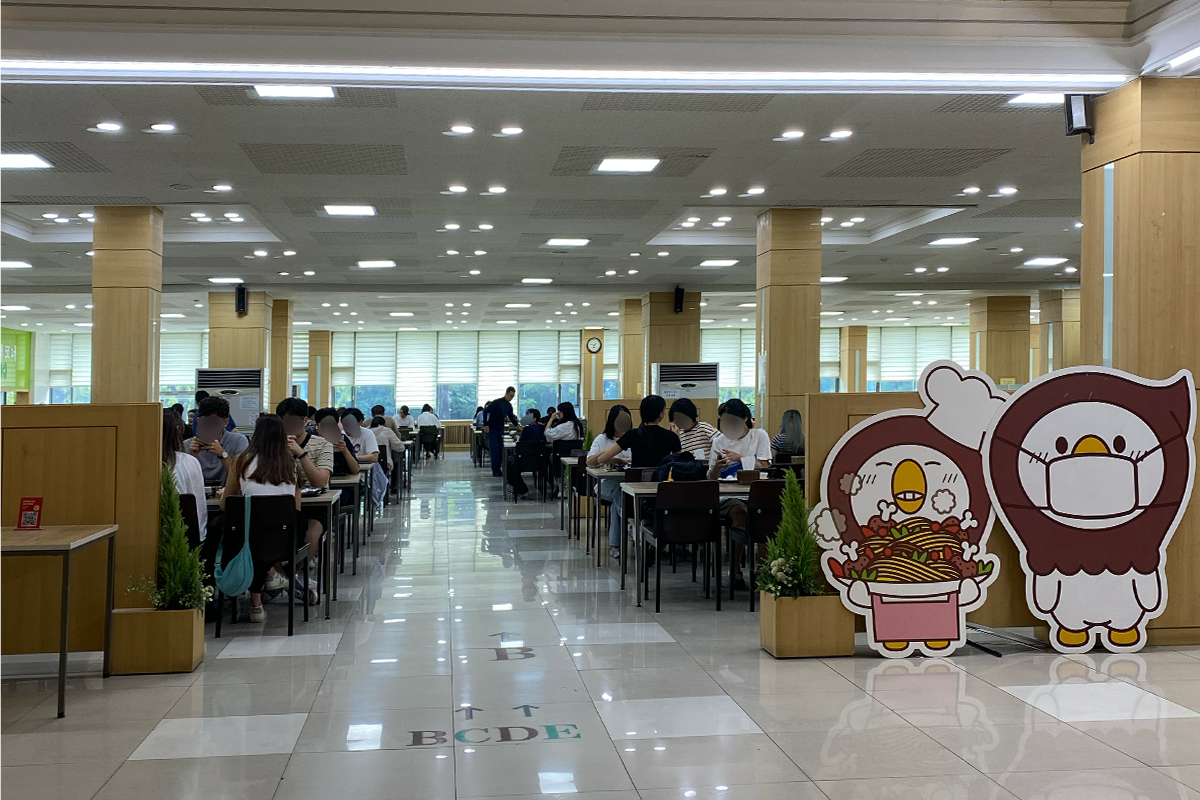 首尔市立大学午餐时间学生会馆食堂全景，许多学生在此享用午餐。