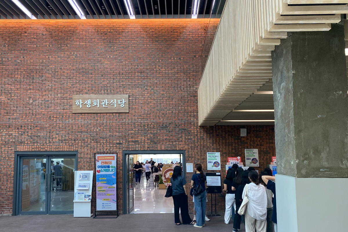 首尔市立大学学生会馆食堂入口，入口处有学生排队等候用餐。