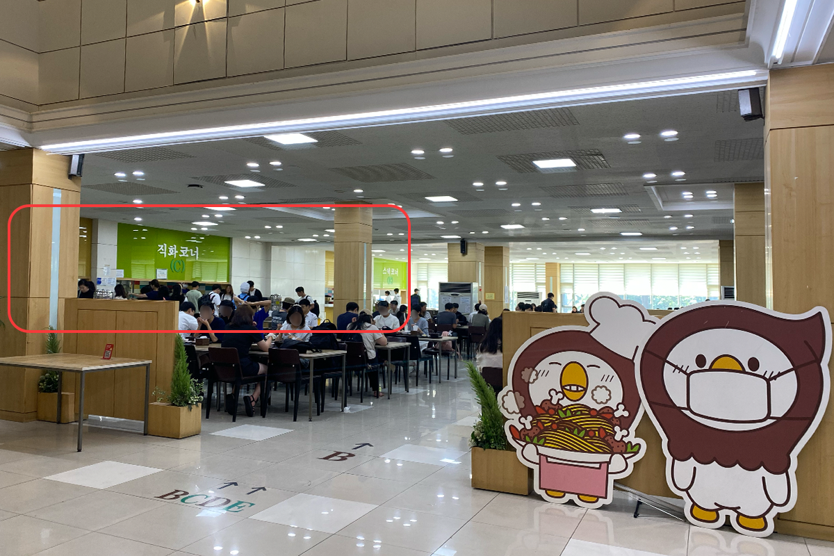 首尔市立大学食堂的B区取餐台，展示学生排队取餐情况。