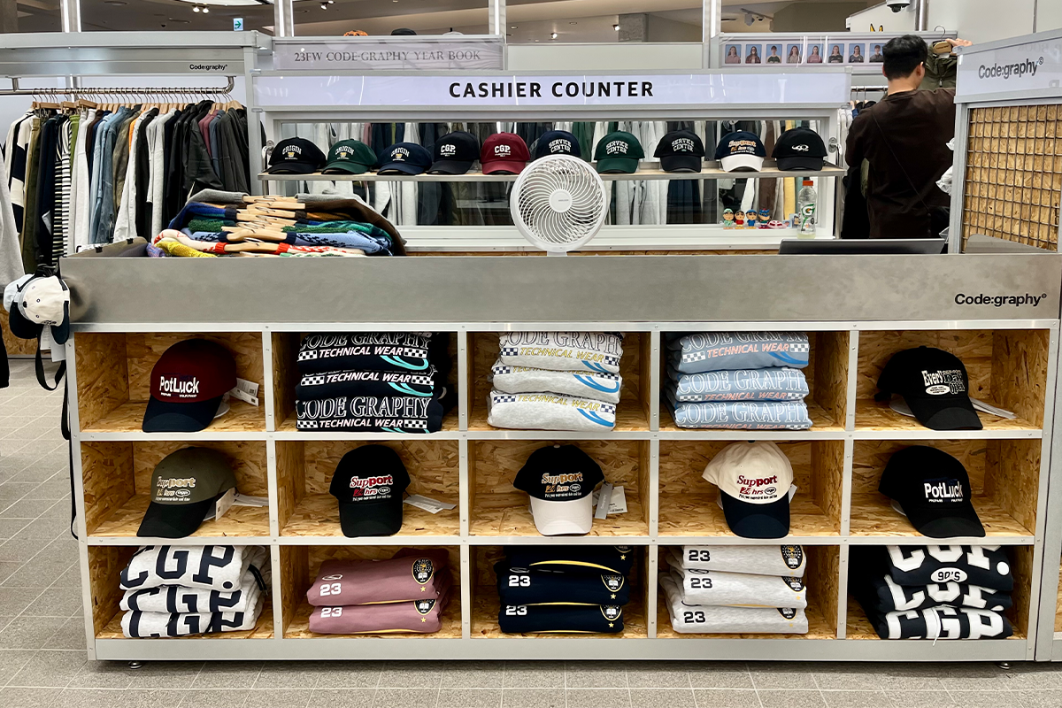 Code:graphy店面擺放的多款服裝與帽子展示櫃，品牌強調休閒與潮流結合。