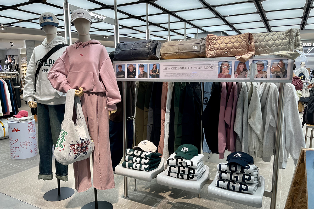 衣架上整齊排列的Code:graphy連帽外套，強調品牌獨特的燕麥色調。