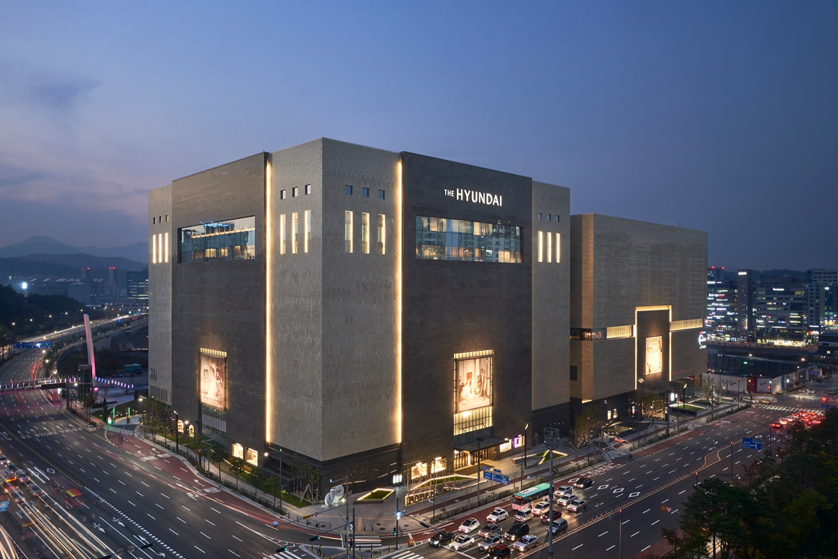 夜幕下的現代百貨外觀，建築物外部被燈光點亮，顯得格外壯觀。