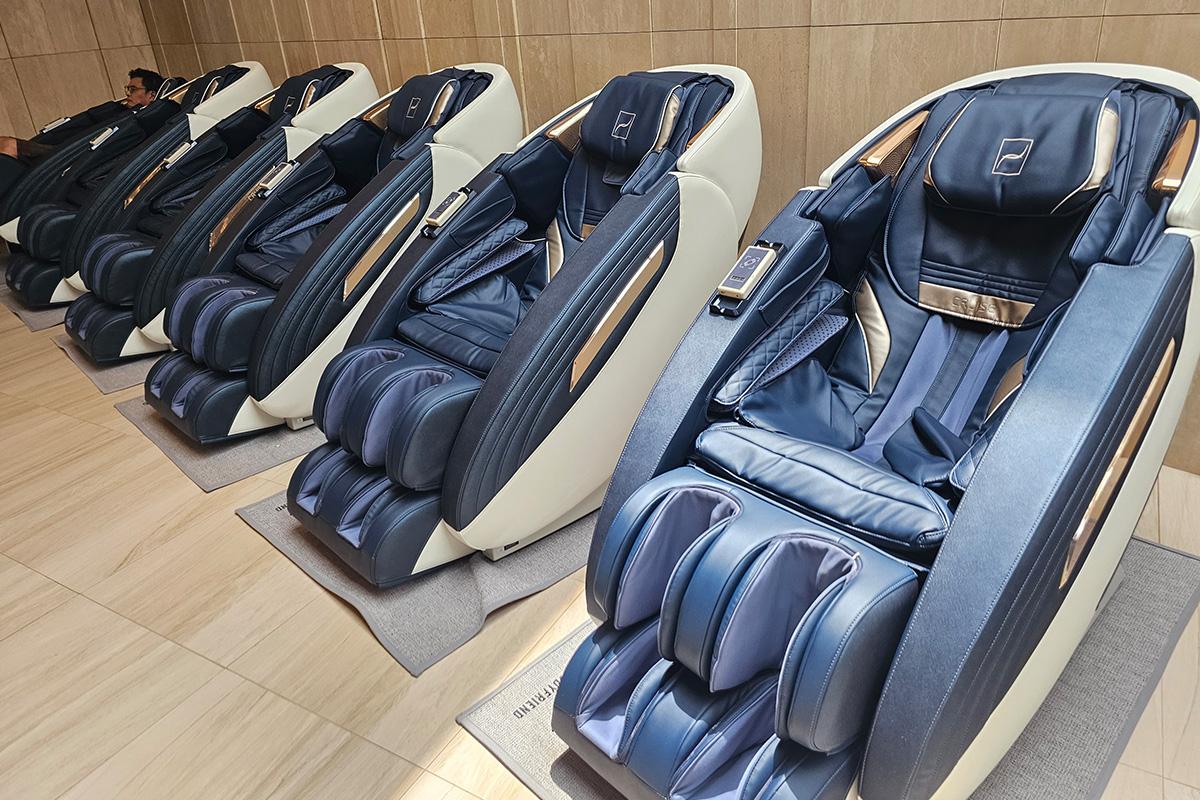 Row of luxurious massage chairs at a Korean jjimjilbang, offering a relaxing spa experience.