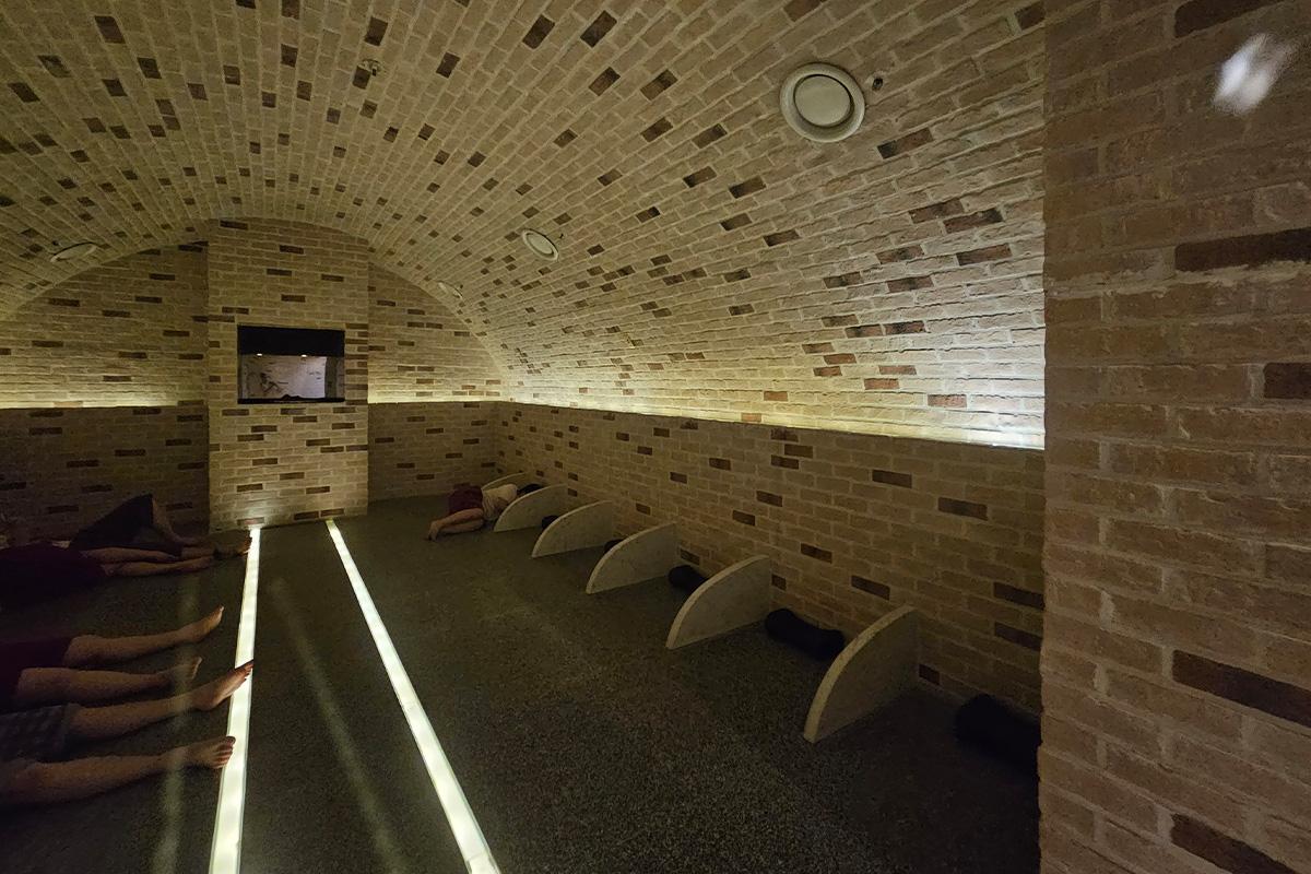 Arch-shaped sauna room interior with stone walls and meditation spaces in a Korean jjimjilbang.