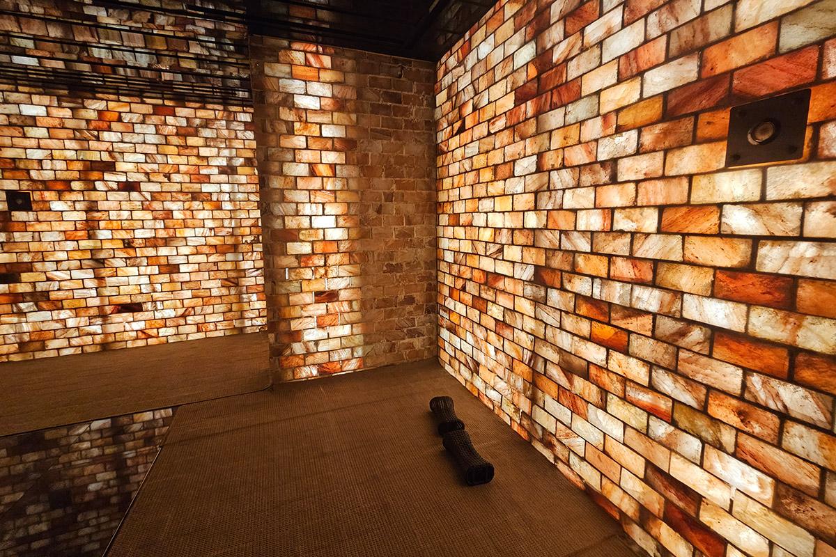 Interior view of a Korean jjimjilbang sauna room with walls made of illuminated salt blocks.