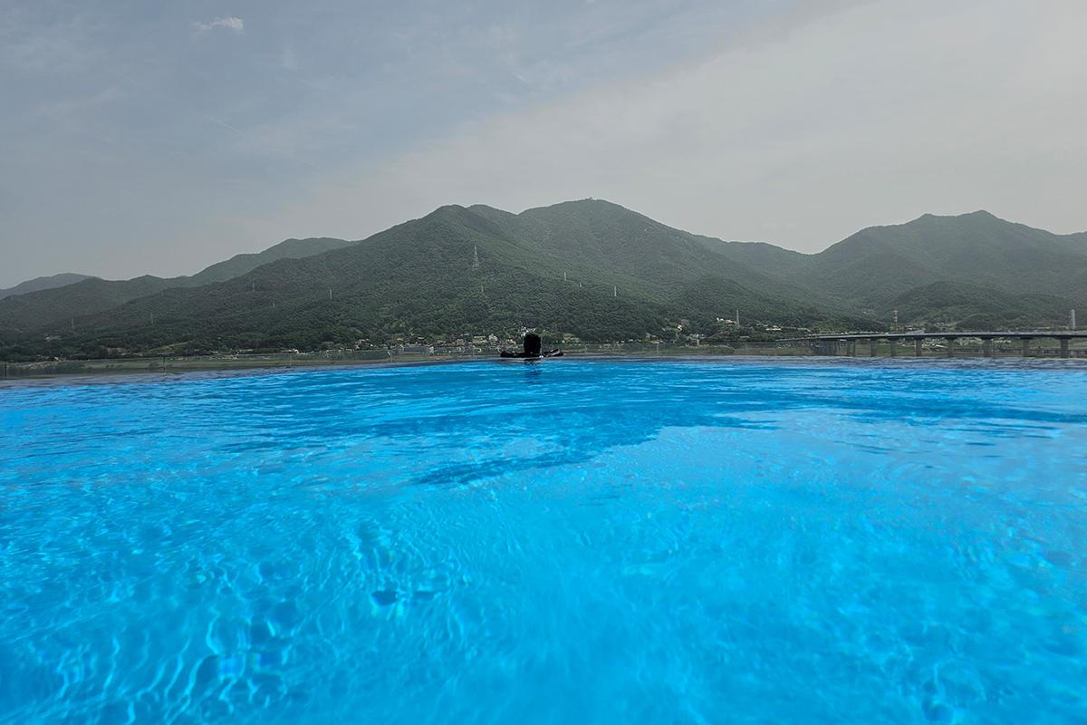 Expansive outdoor swimming pool at Aqua Field with mountainous backdrop