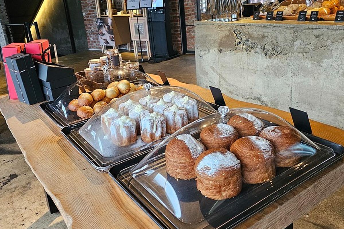 Display of assorted pastries and baked goods at a well-frequented Korean cafe, enticing with delicious variety.