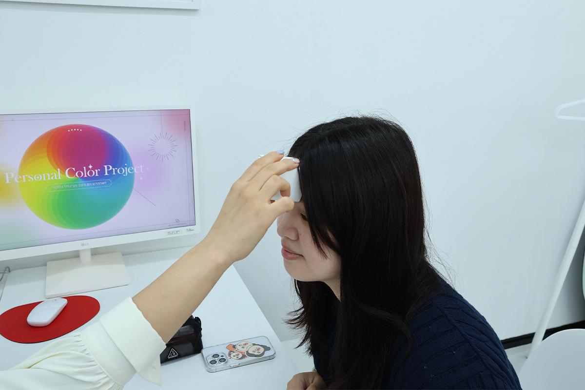 Color consultation at Vivid Kang with use of color measurement device on forehead.