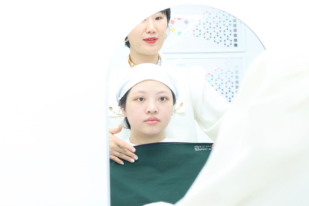 Applying color fabrics to determine personal colors at Vivid Kang.